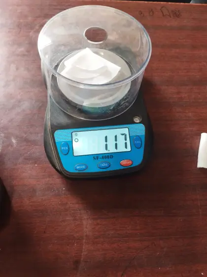 Circular fabric test sample on a precision scale reading 1.17 g