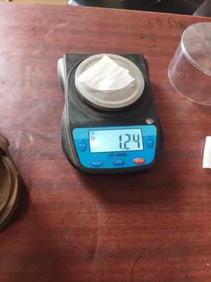 Circular fabric test sample on a precision scale reading 1.24 g